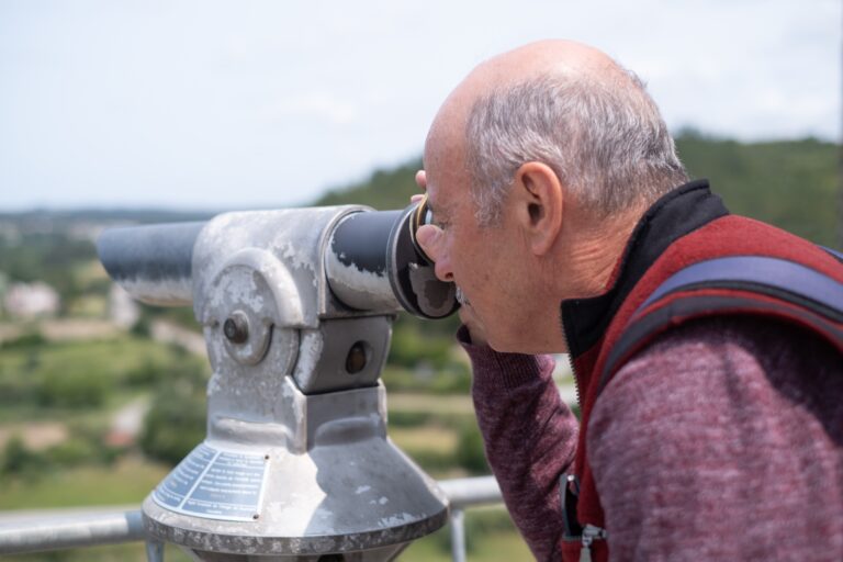 Elderly,Man,Looking,Through,Tourist,Viewing,Telescope,At,Fortress,In